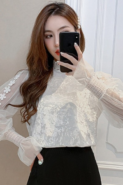 Μια βελούδινη μπλούζα με κολάρο δαντελλών δαντελλών και μανίκια με τούλι