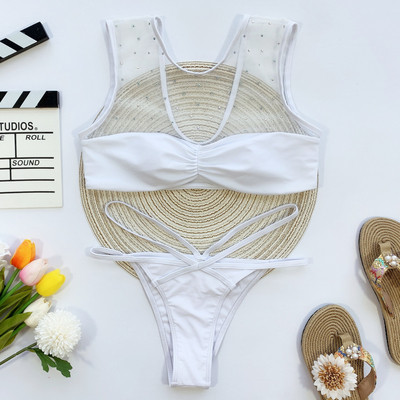 Valge kaheosaline ujumistrikoo rinnakama ülaosa ja kivikestega