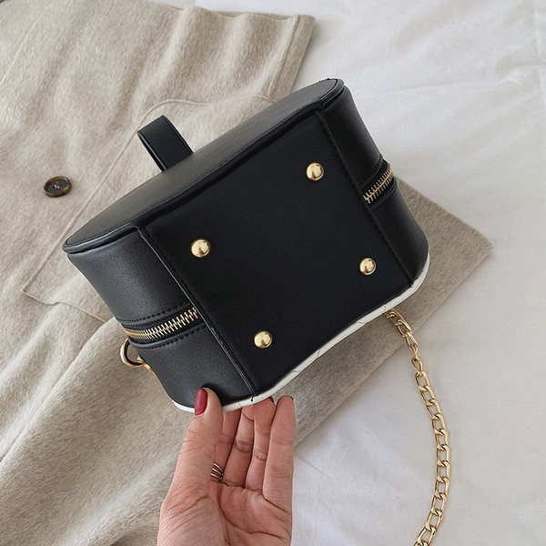 Kerek női táska rövid és hosszú füllel, fém elemekkel