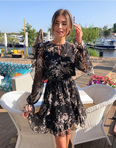 Ένα κομψό γυναικείο κοντό φόρεμα με μακρύ μανίκι και floral σχέδιο