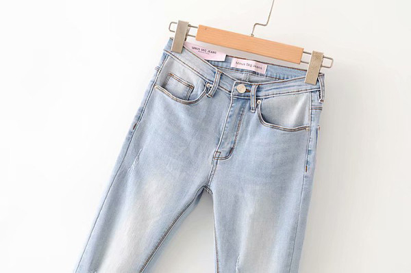 Moodsad kõrge vöökoha ja rebenenud motiividega sinised naiste teksad