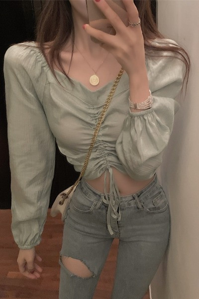 Lühike naiste pluus, millel on volditud esiosa ja lipsud