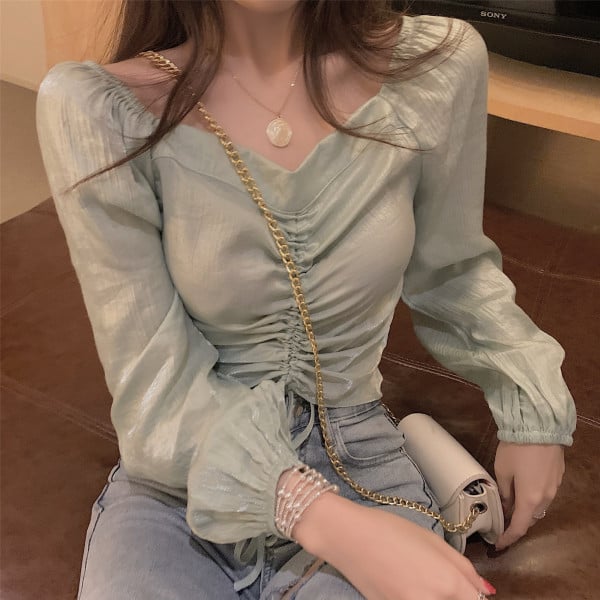 Lühike naiste pluus, millel on volditud esiosa ja lipsud