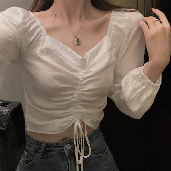 Lühike naiste pluus, millel on volditud esiosa ja lipsud