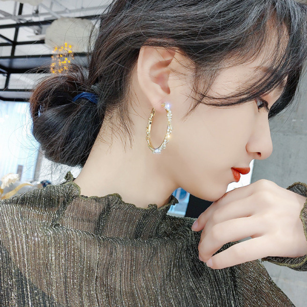 Zlatne ženske naušnice okruglog oblika i kamenčića