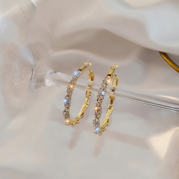 Zlatne ženske naušnice okruglog oblika i kamenčića