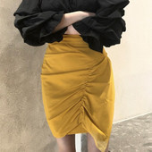 Kollane naiste asümmeetriline kõrge vöökohaga seelik, millel on volditud esiosa