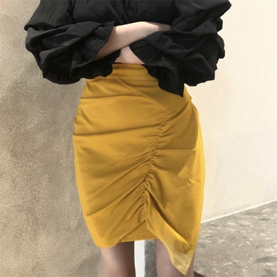 Kollane naiste asümmeetriline kõrge vöökohaga seelik, millel on volditud esiosa