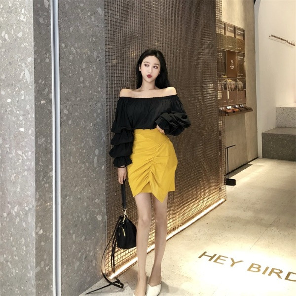 Kollane naiste asümmeetriline kõrge vöökohaga seelik, millel on volditud esiosa