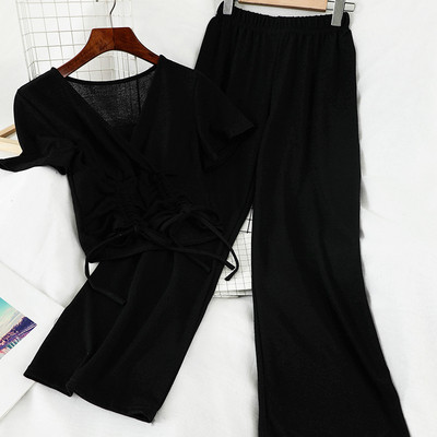 Sport-alkalmi női szett, amely egy rövid nyakkendős pólót és széles, magas derékú nadrágot tartalmaz