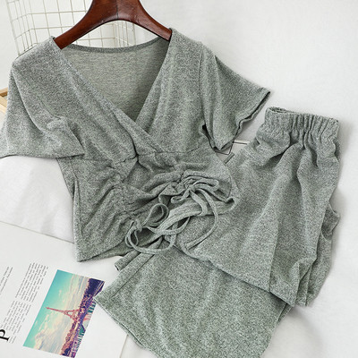 Sport-alkalmi női szett, amely egy rövid nyakkendős pólót és széles, magas derékú nadrágot tartalmaz