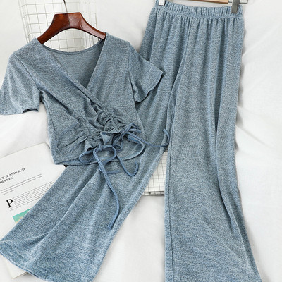 Sport-alkalmi női szett, amely egy rövid nyakkendős pólót és széles, magas derékú nadrágot tartalmaz