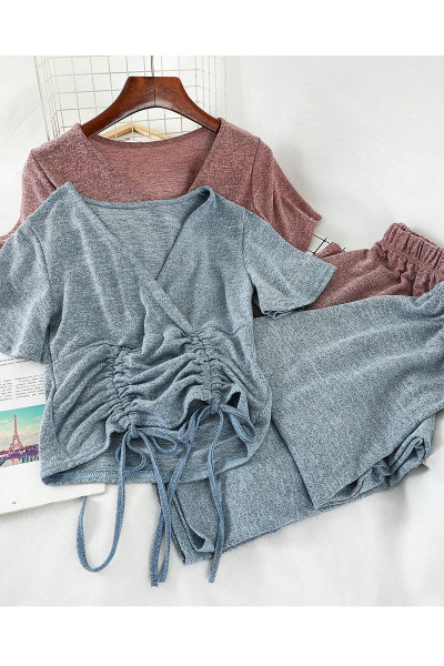 Sport-alkalmi női szett, amely egy rövid nyakkendős pólót és széles, magas derékú nadrágot tartalmaz