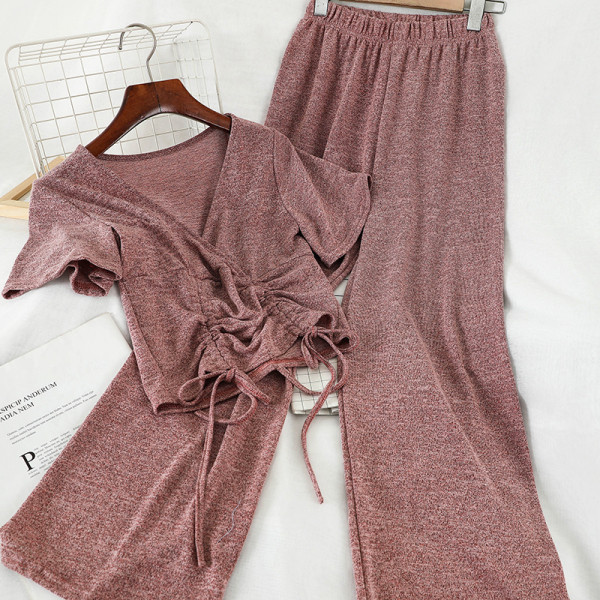 Sport-alkalmi női szett, amely egy rövid nyakkendős pólót és széles, magas derékú nadrágot tartalmaz