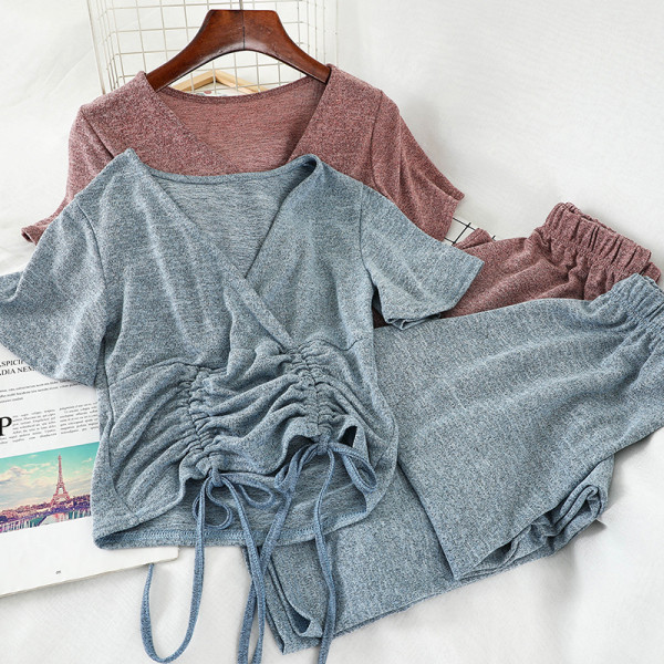 Sport-alkalmi női szett, amely egy rövid nyakkendős pólót és széles, magas derékú nadrágot tartalmaz