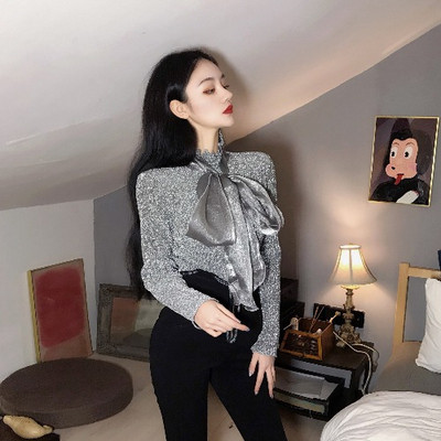 Μοντέρνα γυναικεία μπλούζα με γυαλιστερό εφέ, υψηλό κολάρο και μεγάλη κορδέλα