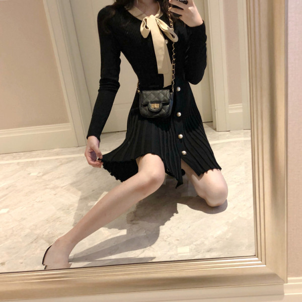 Fekete női ruha gallérral, szalaggal, redős aljával