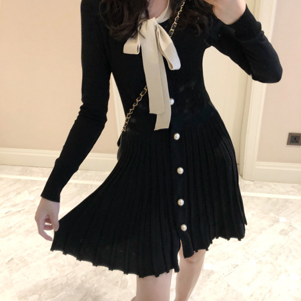 Fekete női ruha gallérral, szalaggal, redős aljával