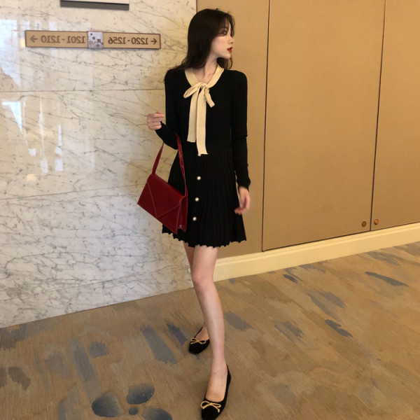 Fekete női ruha gallérral, szalaggal, redős aljával