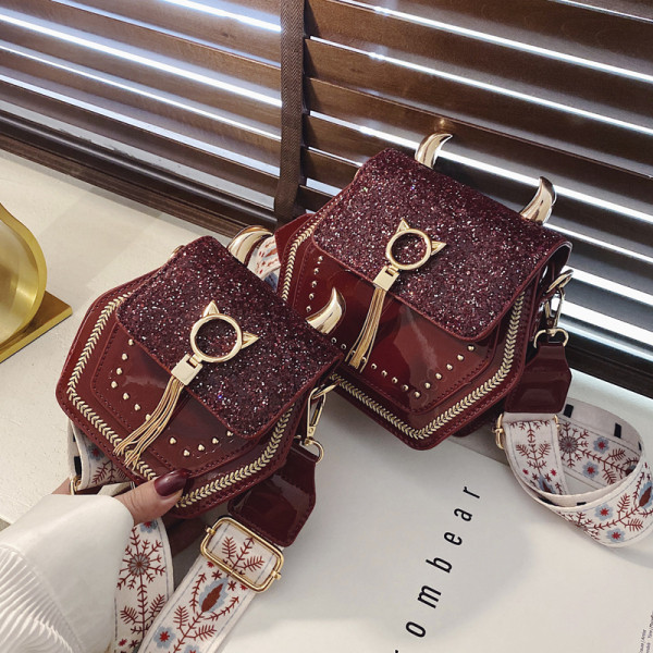 Kaasaegne naistekott pika värvilise sanga, läikiva efekti ja metallist elementidega