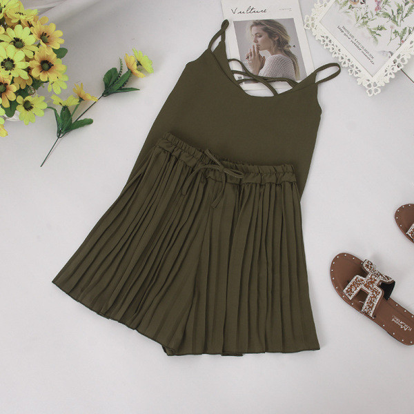 Modern nyári szett vékony pántokkal ellátott felsőt és magas derékú, redőzött rövidnadrágot tartalmaz