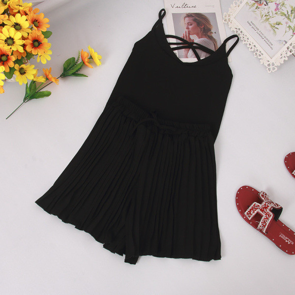 Modern nyári szett vékony pántokkal ellátott felsőt és magas derékú, redőzött rövidnadrágot tartalmaz