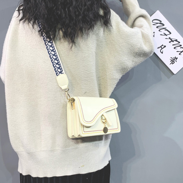 Kis négyzet alakú táska ökobőrből és hosszú textil fogantyúval