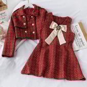 Stilingas moteriškas komplektas, kurį sudaro suknelė su kaspinu ir trumpas švarkas su sagomis