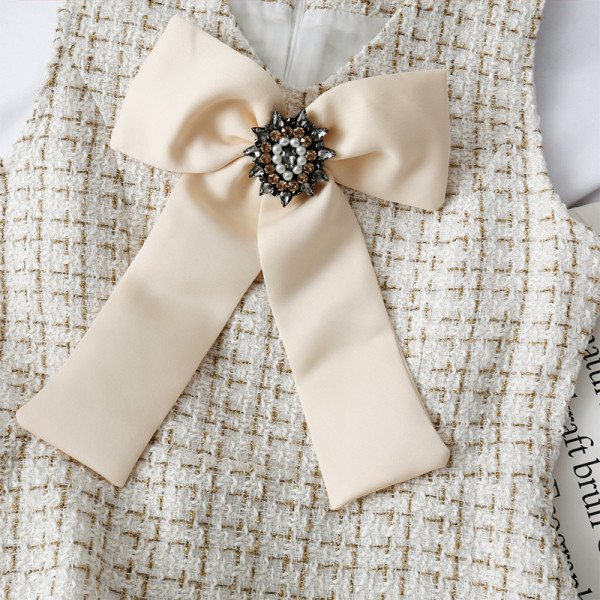 Stilingas moteriškas komplektas, kurį sudaro suknelė su kaspinu ir trumpas švarkas su sagomis