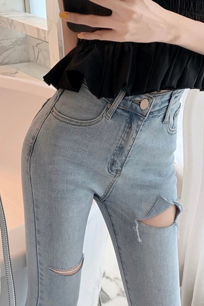 Testhezálló női farmer magas derékkal, szakadt motívumokkal