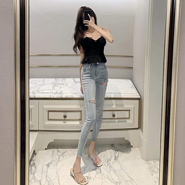 Testhezálló női farmer magas derékkal, szakadt motívumokkal