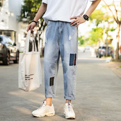 Modernus vyriškų džinsų platus modelis su suplyšusiais motyvais ir lopais