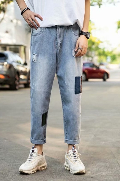 Modernus vyriškų džinsų platus modelis su suplyšusiais motyvais ir lopais