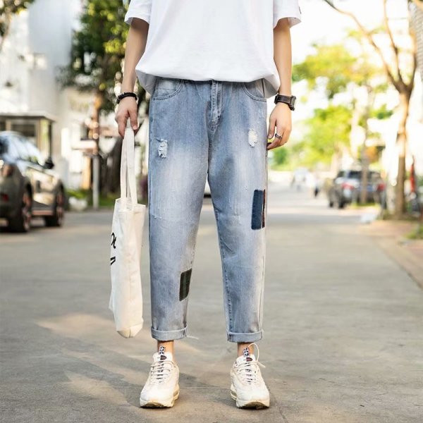 Modernus vyriškų džinsų platus modelis su suplyšusiais motyvais ir lopais