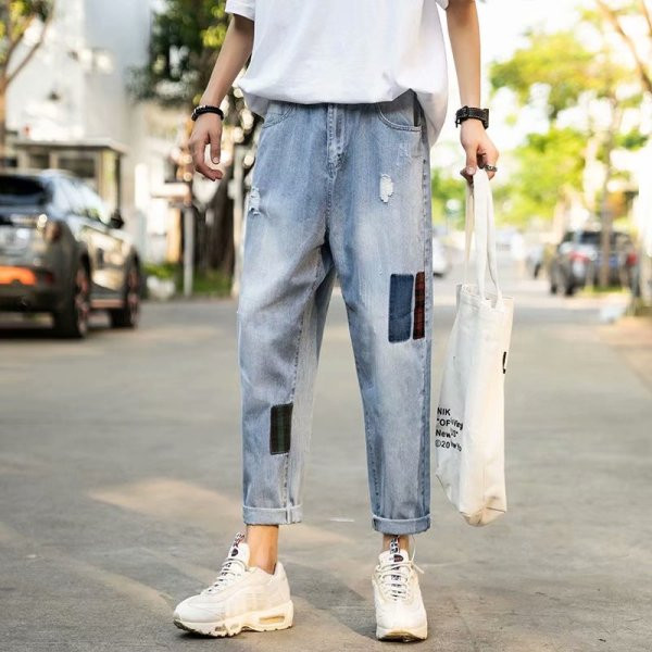 Modernus vyriškų džinsų platus modelis su suplyšusiais motyvais ir lopais