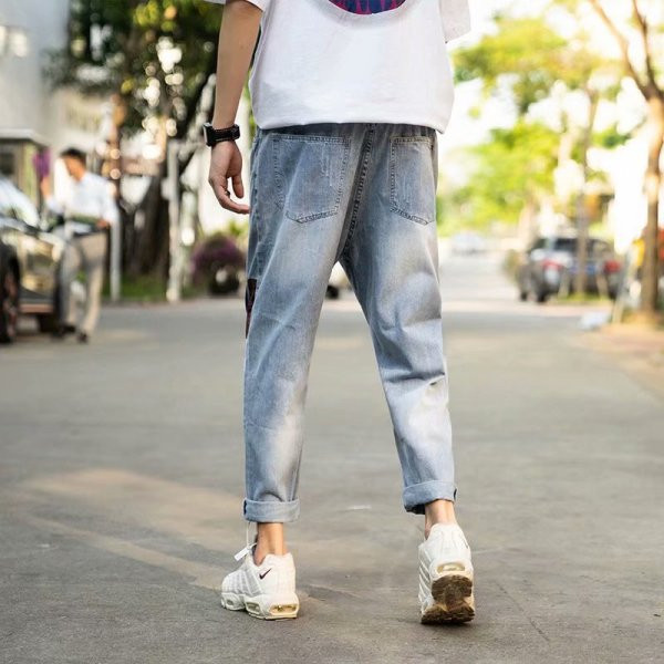 Modernus vyriškų džinsų platus modelis su suplyšusiais motyvais ir lopais