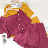 Moteriškas komplektas, kurį sudaro šortai aukštu juosmeniu ir palaidinė su sagomis