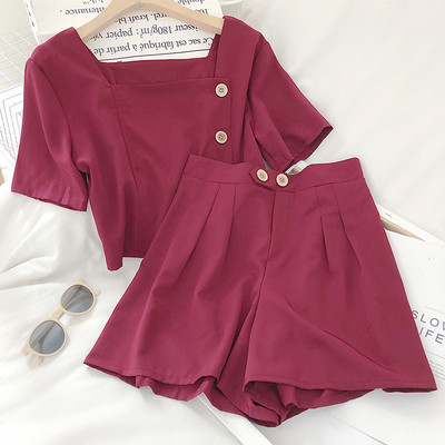 Moteriškas komplektas, kurį sudaro šortai aukštu juosmeniu ir palaidinė su sagomis