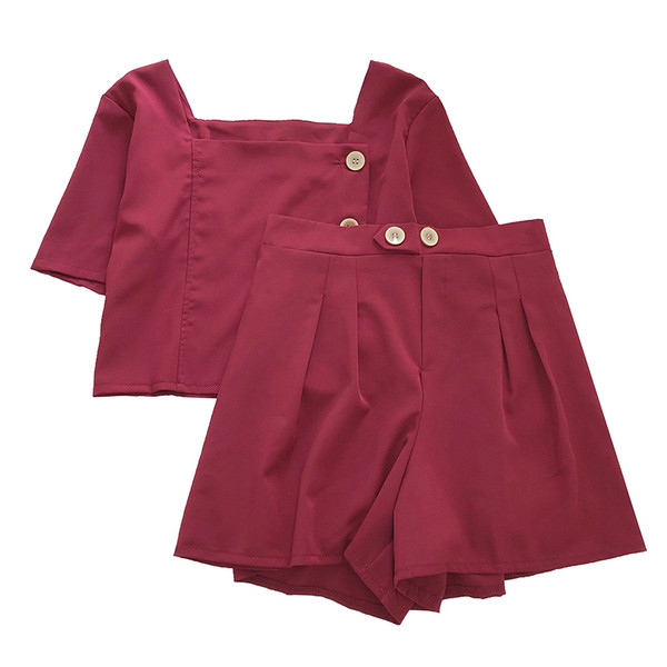 Moteriškas komplektas, kurį sudaro šortai aukštu juosmeniu ir palaidinė su sagomis