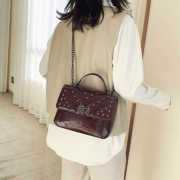 Hétköznapi női táska fém elemekkel és hosszú füllel