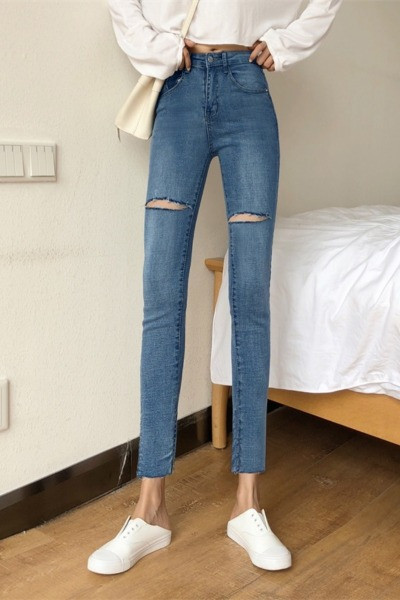 Testhezálló női farmer magas derékkal, szakadt motívumokkal