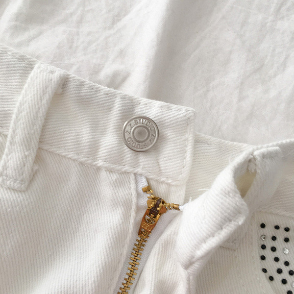 Balti moteriški šortai aukštu liemeniu, plėšytais motyvais ir akmenukais