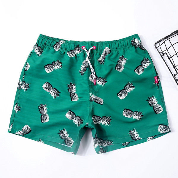 Jauns vīriešu pludmales šortu modelis ar elastīgu jostasvietu un labo ar ananāsiem