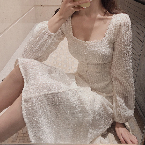 Balta sieviešu kleita ar kvadrātveida kakla izgriezumu un pogām