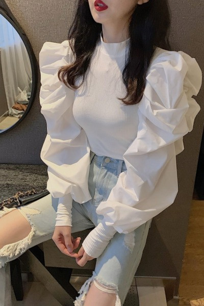 Moderna sieviešu blūze ar pufām piedurknēm un zemu apkakli ap kaklu