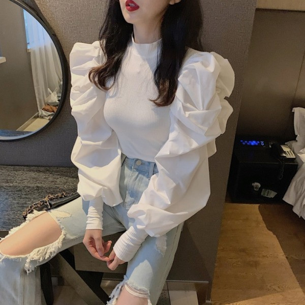 Moderna sieviešu blūze ar pufām piedurknēm un zemu apkakli ap kaklu