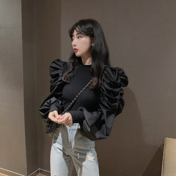 Moderna sieviešu blūze ar pufām piedurknēm un zemu apkakli ap kaklu