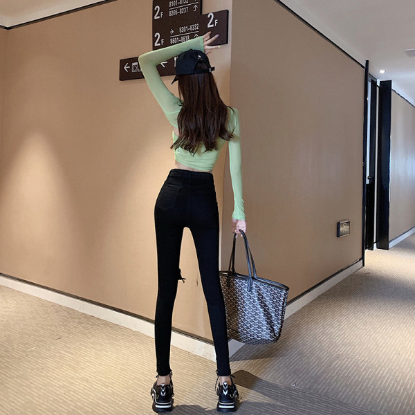 Moderns sieviešu džinsu modelis ar augstu vidukli un saplēstiem motīviem