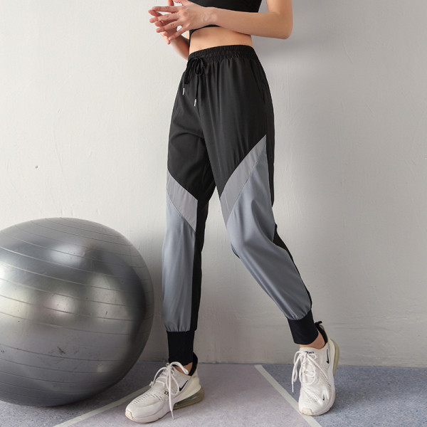 Moteriškų sportinių kelnių platus modelis su aukštu juosmeniu ir šviesą atspindinčiais elementais