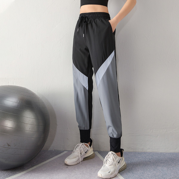 Moteriškų sportinių kelnių platus modelis su aukštu juosmeniu ir šviesą atspindinčiais elementais